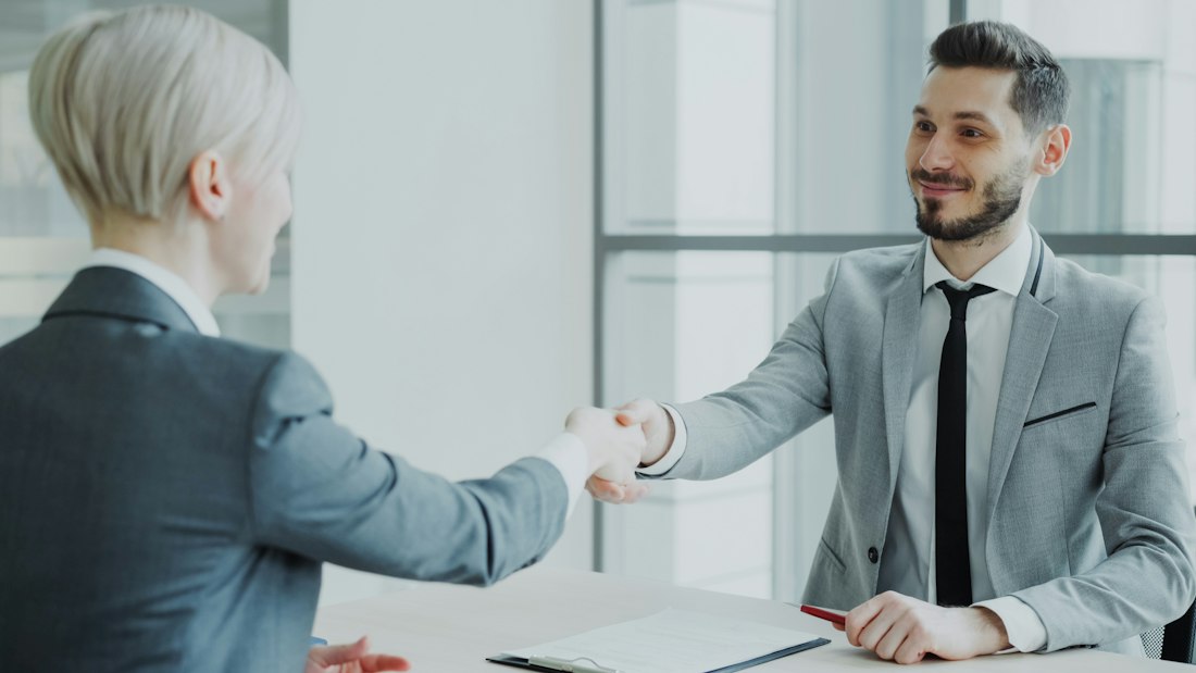 Two professionals shaking hands in a meeting